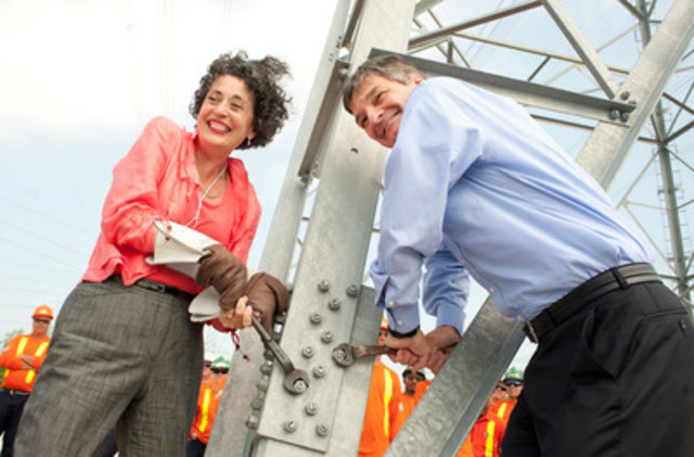 Minister Chris Bentley and Hydro One President and CEO, Laura Formusa tighten the last bolt on the final tower in the Bruce to Milton transmission project.